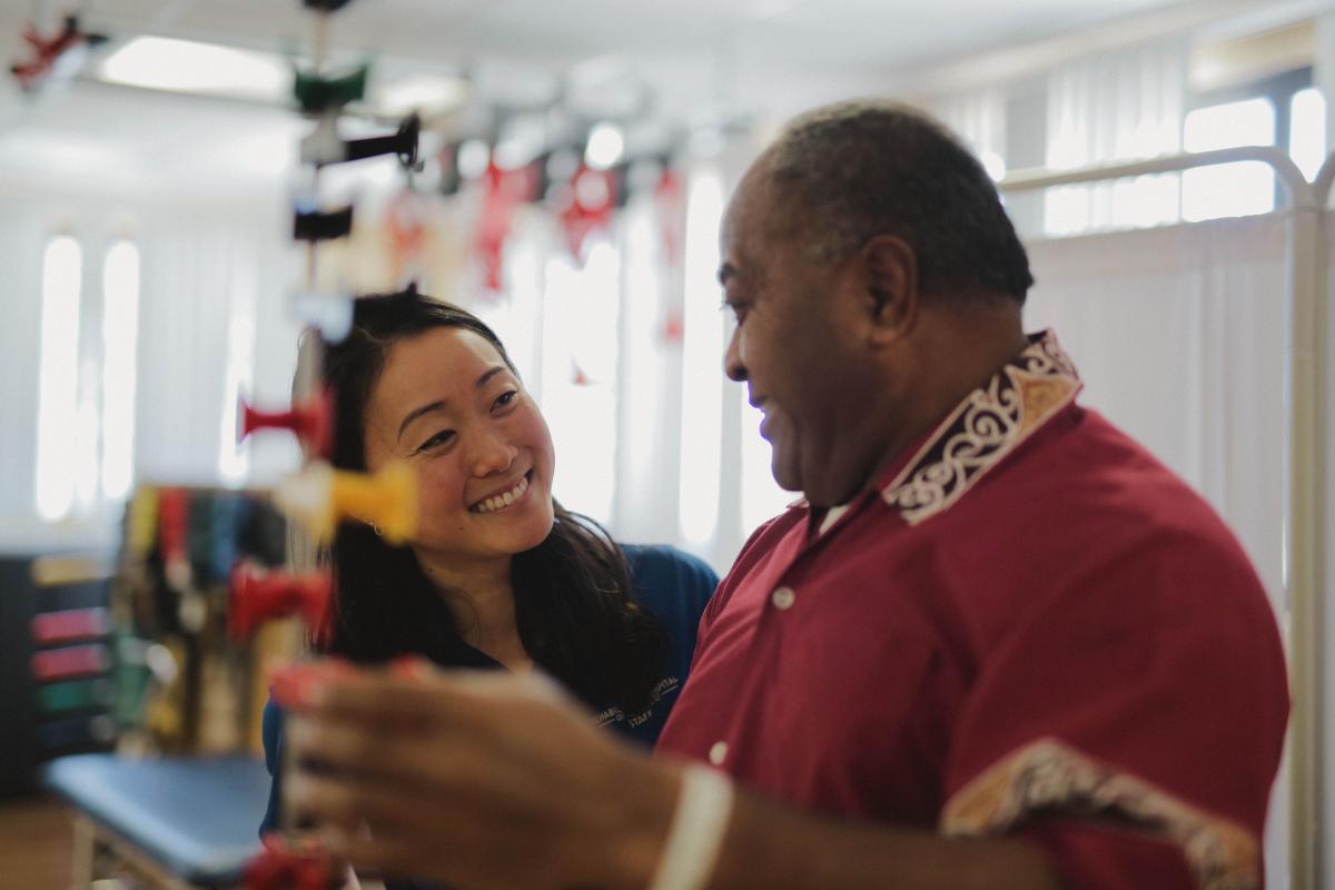 REHAB staff member helping stroke rehabilitation patient