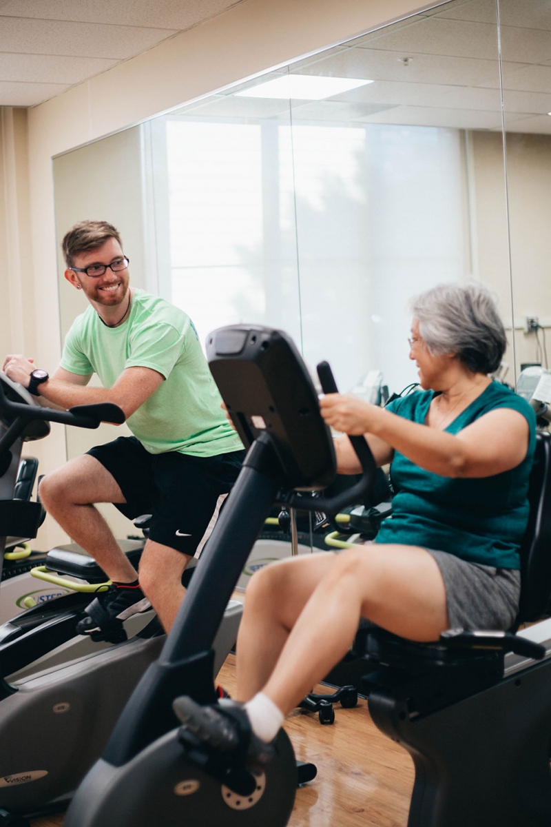 two people on separate workout machines looking at each other