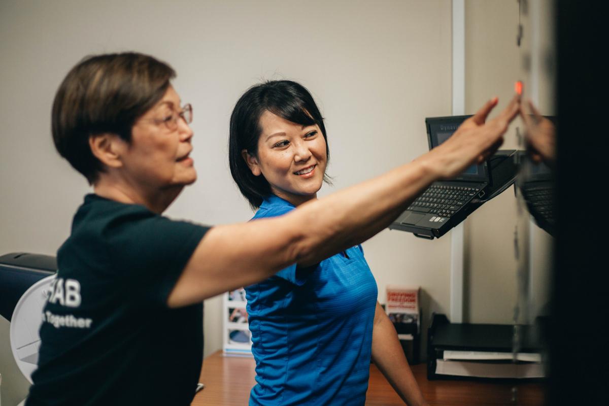 Rehab Hospital staff member assisting a patient using DynaVision technology