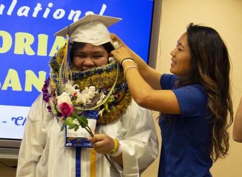 Graduate receiving leis from a friend