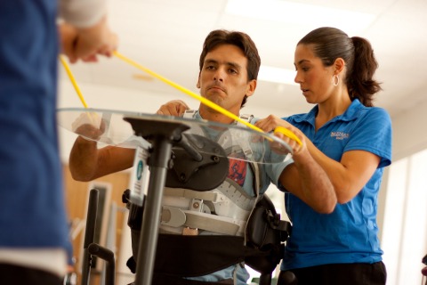 Trainer helps patient with shoulders