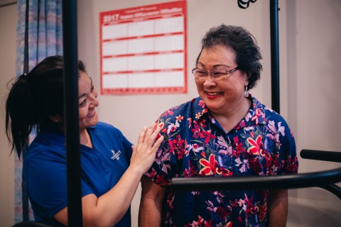 Nurse helping elderly woman on machine