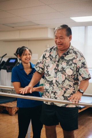 Therapist helping patient stand, balance, and walk