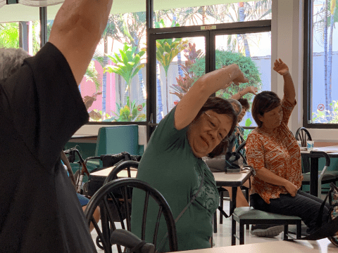 elderly stretching while sitting in chairs