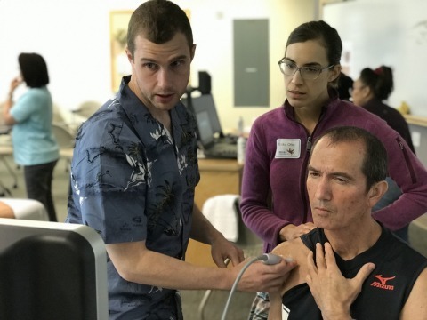 Staff inspecting patient's shoulder