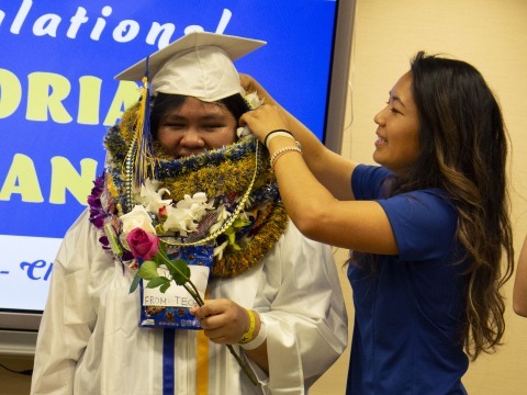 Graduate receiving leis from a friend