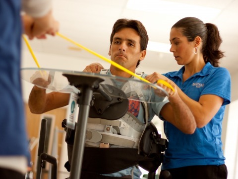 Trainer helps patient with shoulders