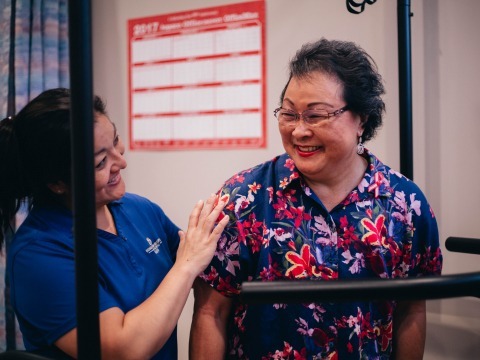 Nurse helping elderly woman on machine