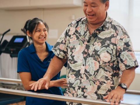 Therapist helping patient stand, balance, and walk